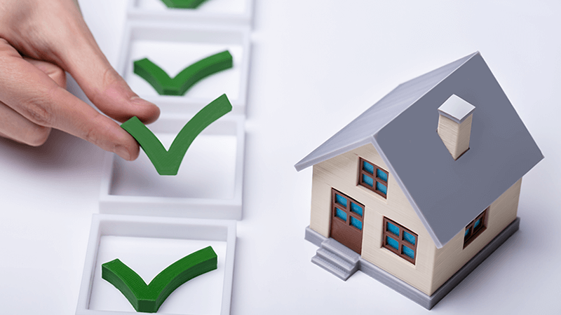 A model house and checklist with hand holding 3d green checkmark